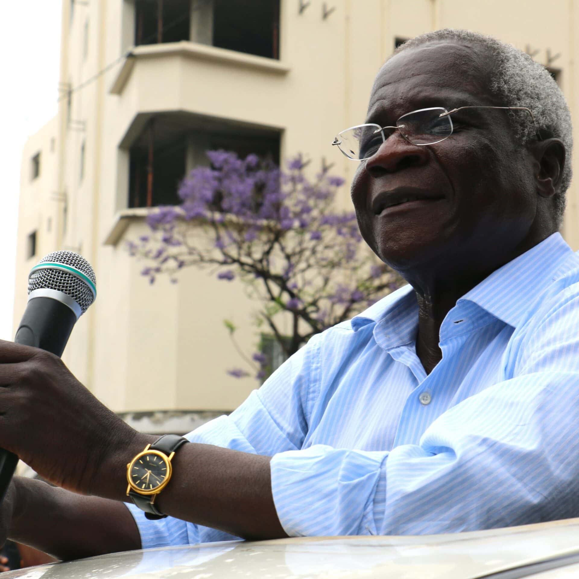 Afonso Dhlkama gives a speech through the roof window of a car.