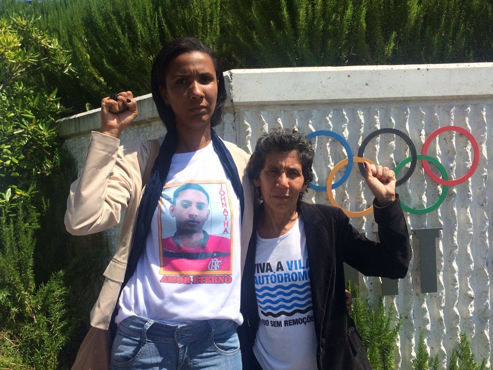 Ana Paula Gomes de Oliveira with her raised fist in front of the UNO building Behind her the flags of the member countries.