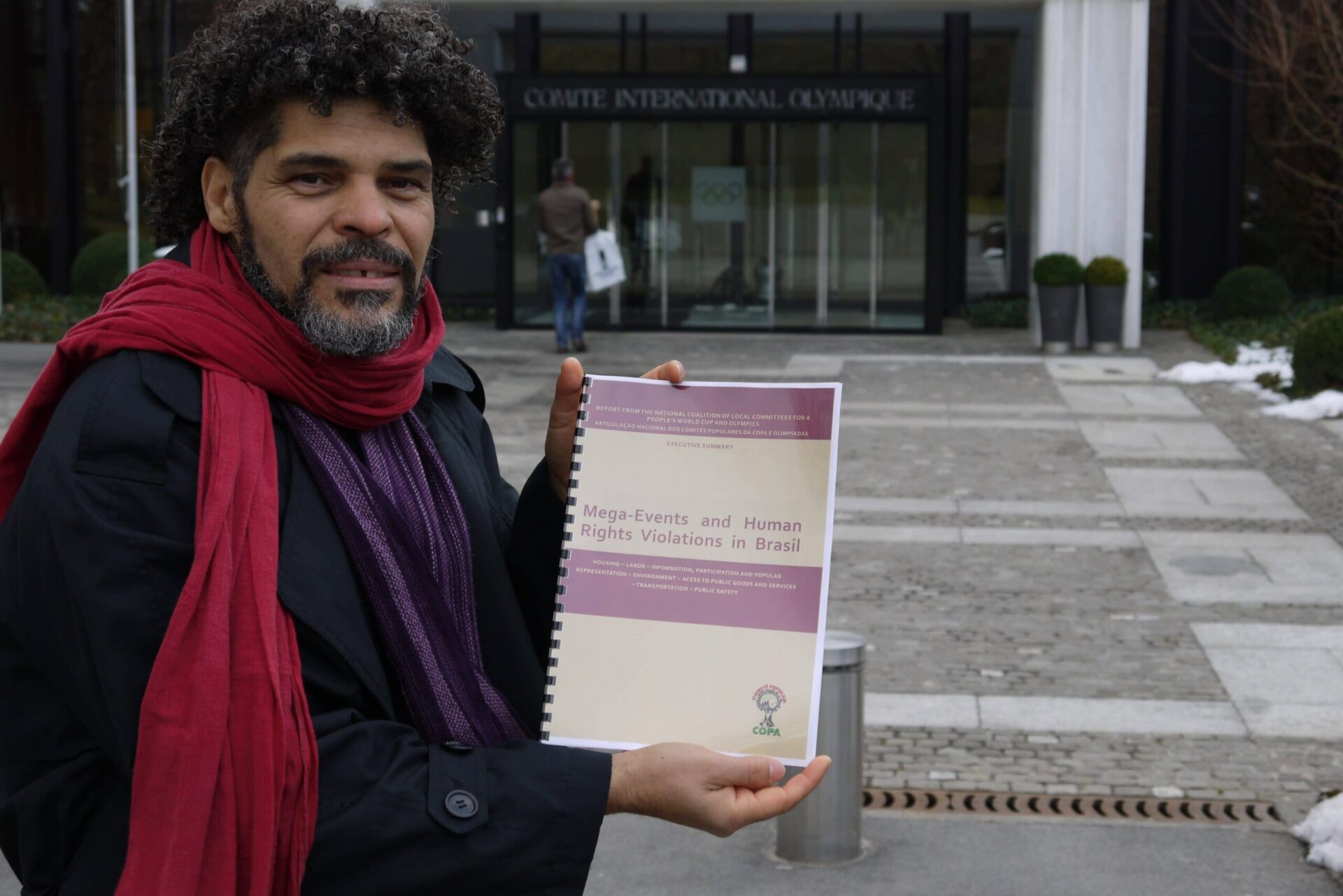 Argemiro at the entrance to the International Olympic Committee. He is holding a report entitled: Mega-Events and Human Rights Violations in Brazil.