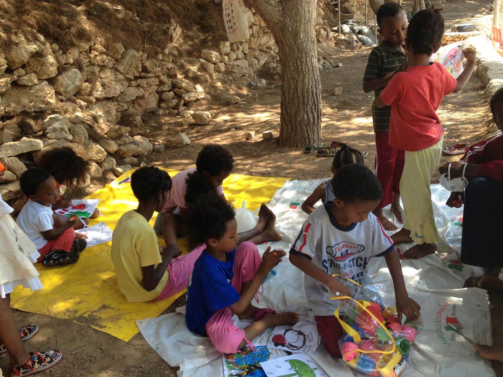 Children draw and play outside on the floor.