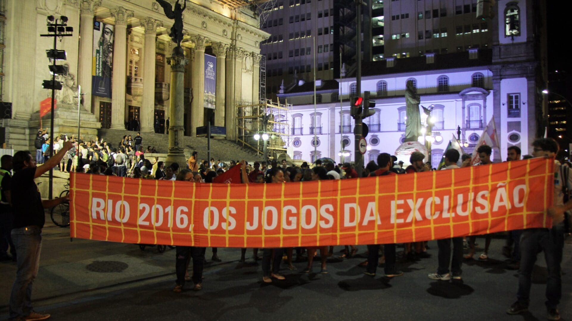 Demonstrators in front of the Parlemts building in Rio with a poster with the inscription: Rio 2016 - Os Jogos da Exclusao.