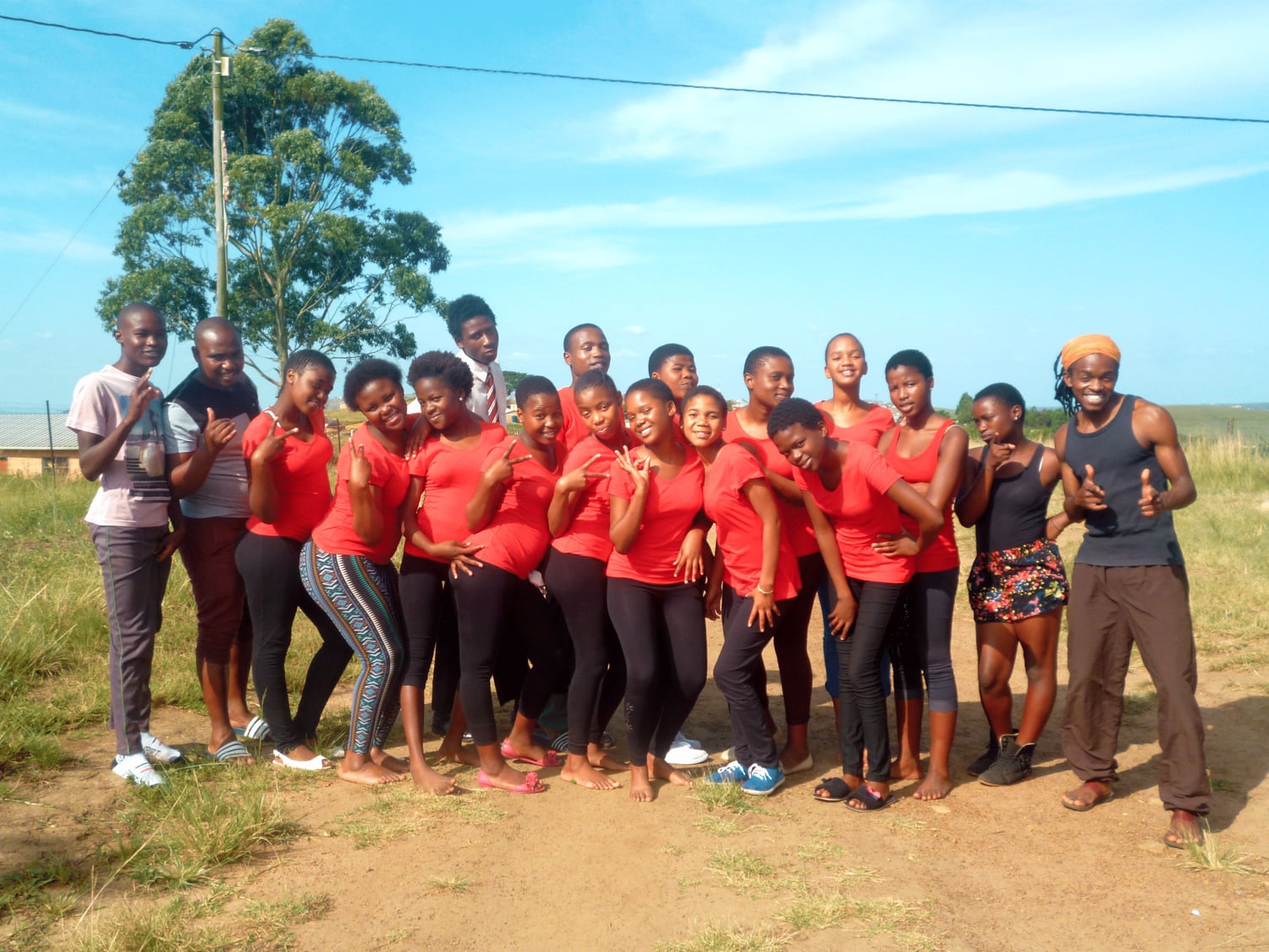 Group picture with 18 teenagers in red t-shirts.