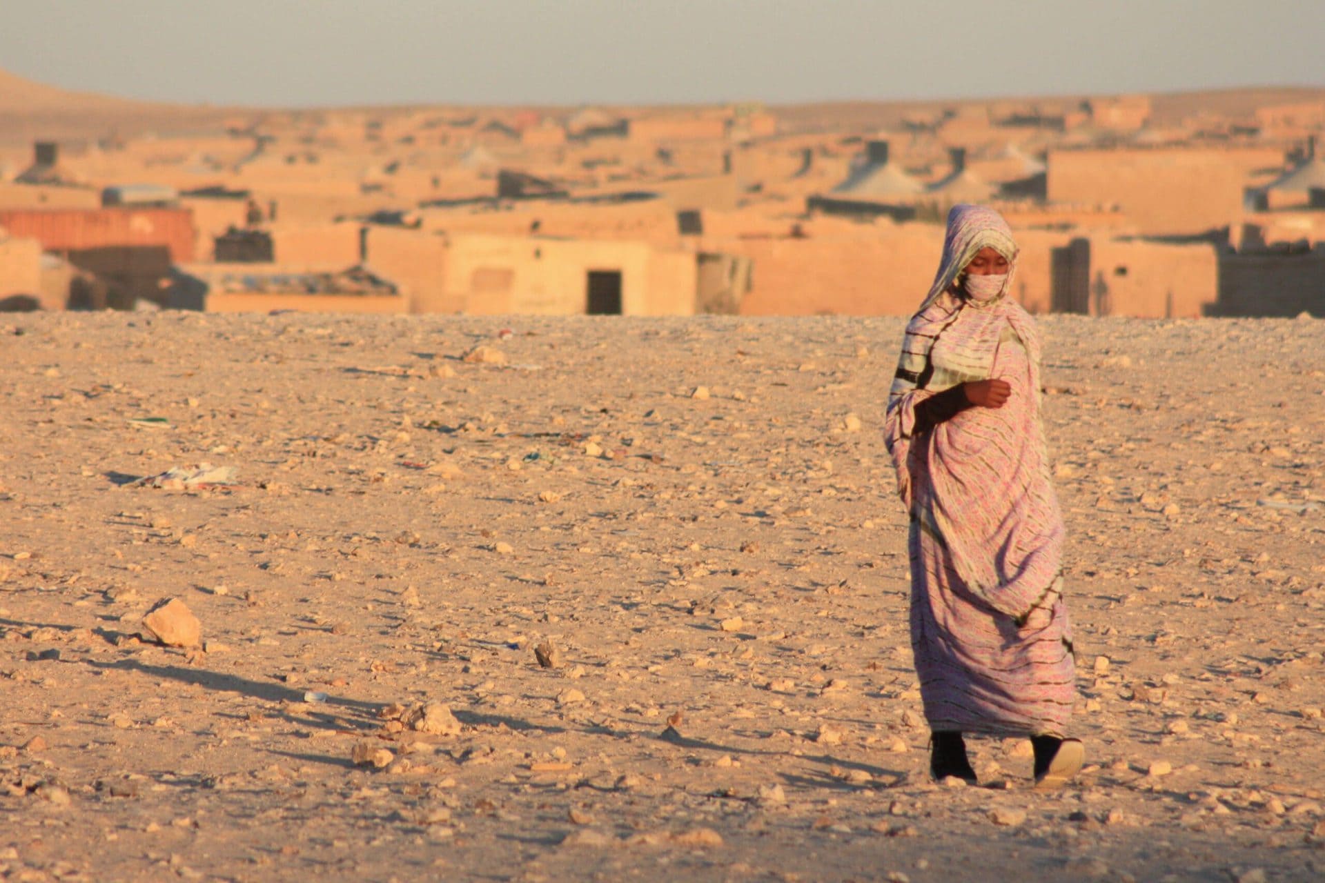 Young woman in the foreground, camp in the background.