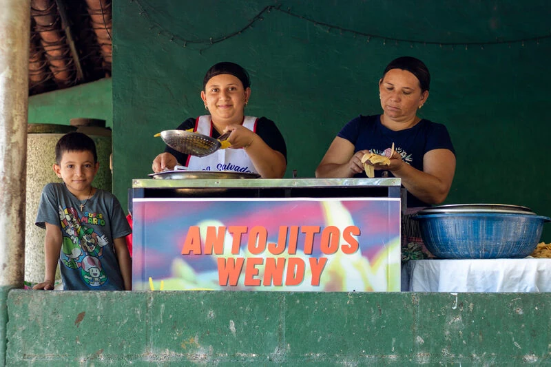 Zwei-Frauen-hinter-einem-kleinen-Imbissstand-mit-der-Aufschrift-Antojitos-Wendy