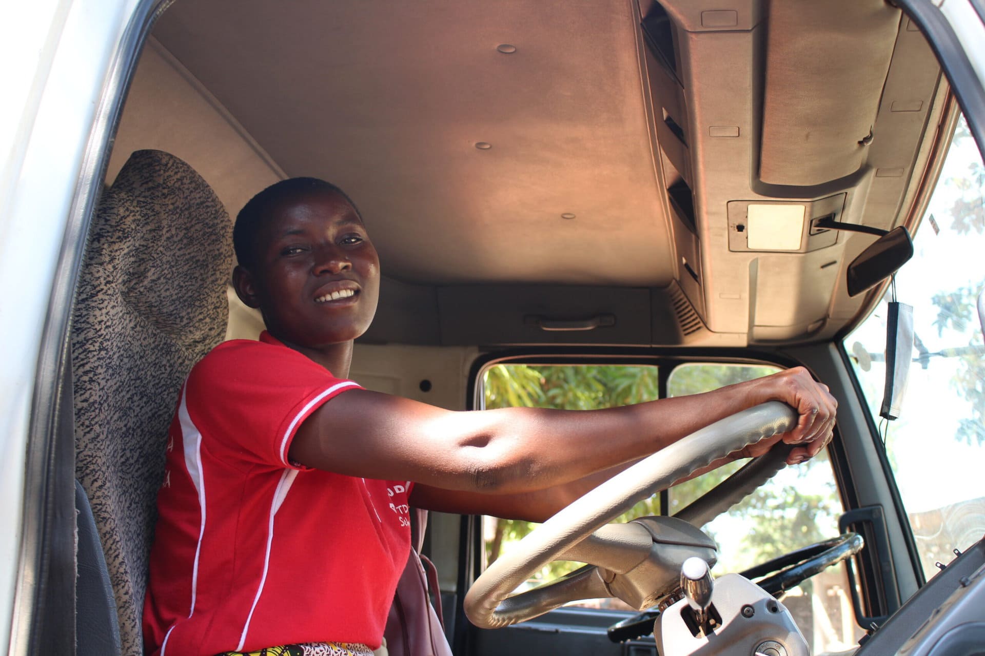 Young woman behind the wheel of a truck - terre des hommes schweiz